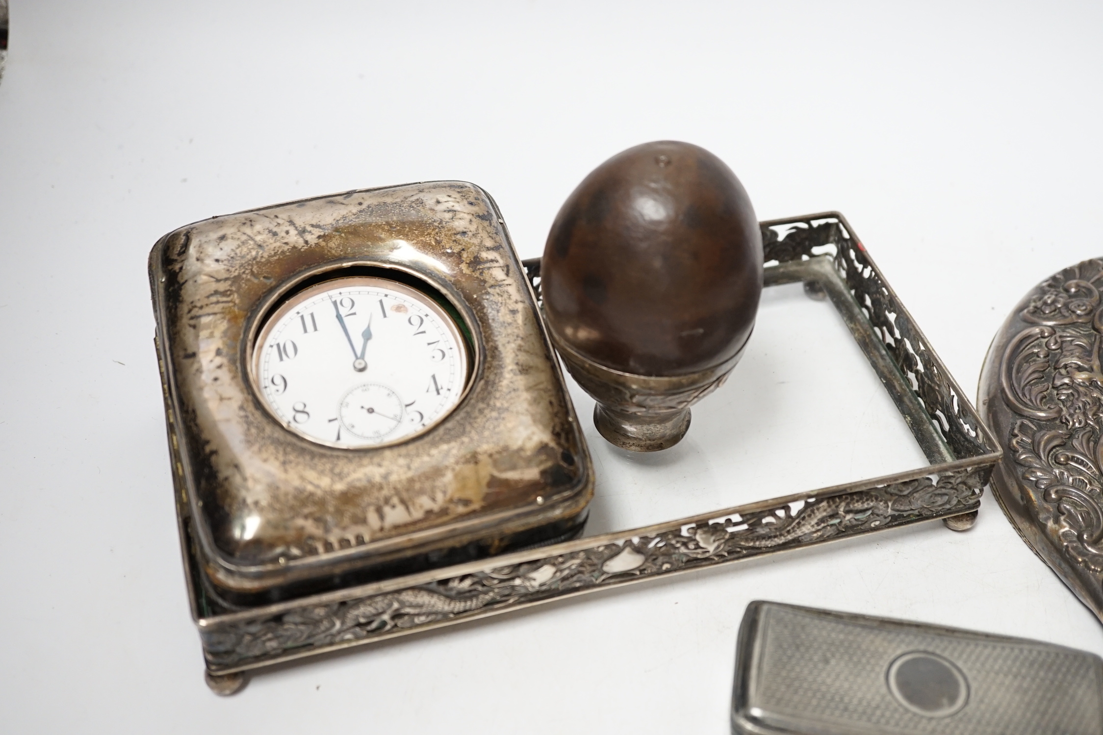 An Edwardian silver mounted travelling pocket watch case, Birmingham, 1905, with nickel cased pocket watch, together with a repousse silver mounted hand mirror, a Chinese white metal mounted glass dressing table tray and